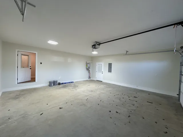 a view of house that has wooden fence and two of trees