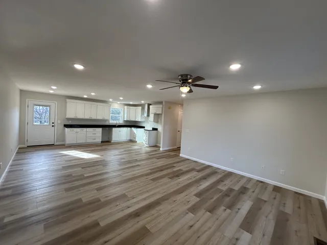 a view of an empty room with wooden floor