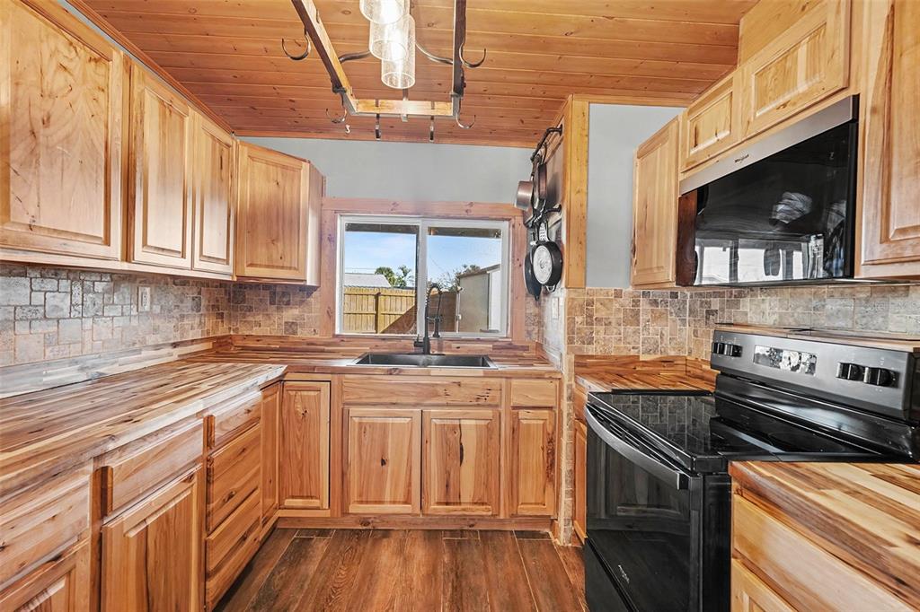 557 Flame Tree Drive Apollo Beach, FL 33572 - Photo 12 of 31 a kitchen with stainless steel appliances granite countertop a sink and cabinets