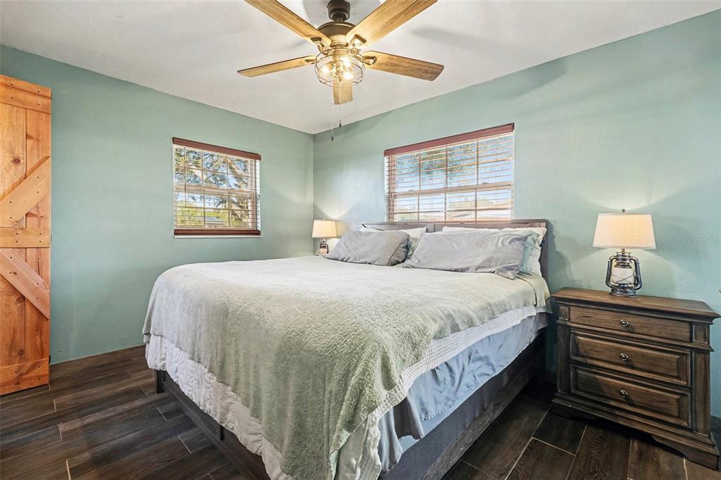 557 Flame Tree Drive Apollo Beach, FL 33572 - Photo 15 of 31 a bedroom with a bed and a chandelier