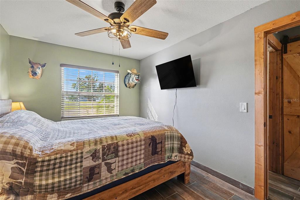 557 Flame Tree Drive Apollo Beach, FL 33572 - Photo 18 of 31 a bedroom with a bed a flat screen tv and a window