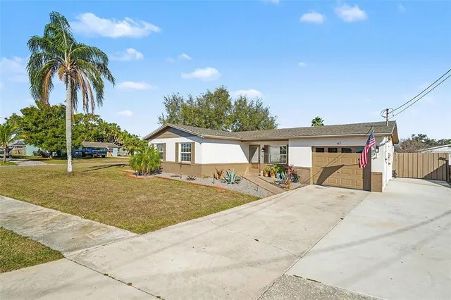 a view of house with outdoor space and palm trees