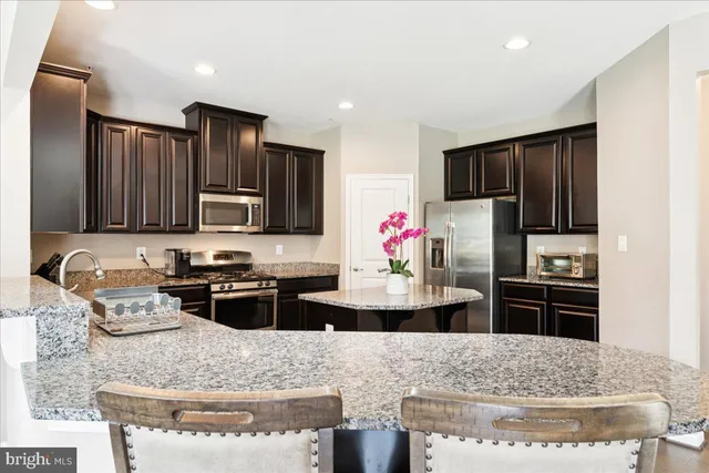 a kitchen with stainless steel appliances granite countertop a refrigerator and stove