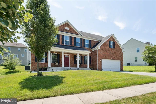 a front view of a house with a yard and trees