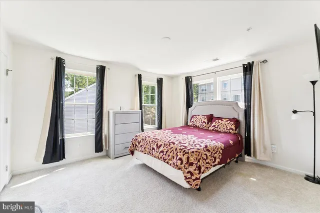 a bedroom with a bed painting and a window