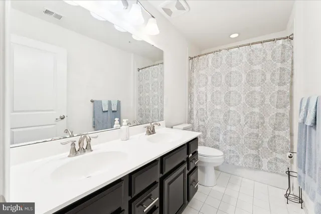 a bathroom with a sink a toilet a mirror and shower