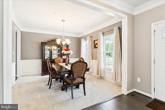 a dining room with furniture a chandelier and wooden floor