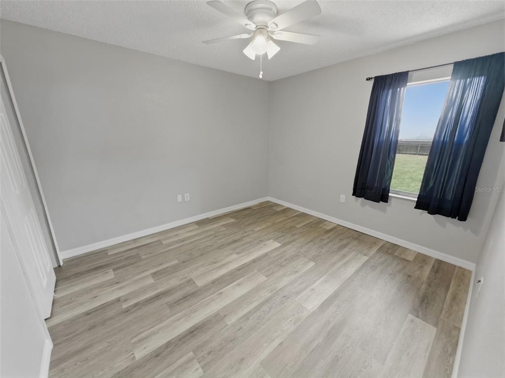 2202 Godfrey Avenue Spring Hill, FL 34609 - Photo 28 of 36 an empty room with wooden floor and fan