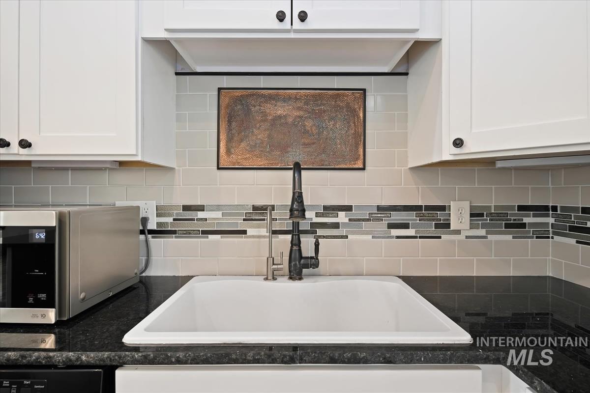 2417 Patch Ditch Road Homedale, ID 83628 - Photo 14 of 50 Kitchen featuring white cabinets, stainless steel microwave, and backsplash