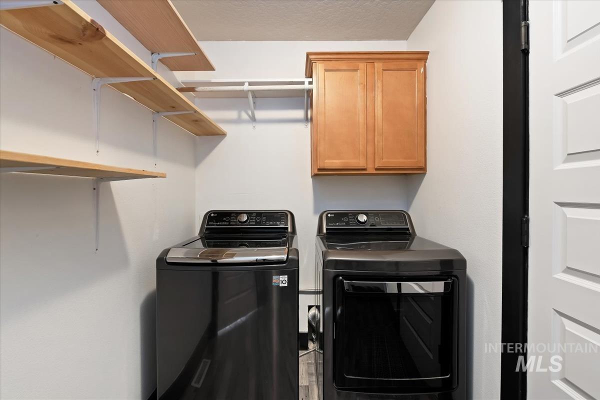 2417 Patch Ditch Road Homedale, ID 83628 - Photo 26 of 50 Laundry room featuring cabinet space, washing machine and clothes dryer, and a textured ceiling