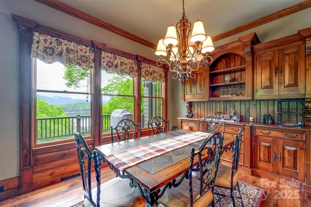 a dining room with furniture a chandelier and wooden floor