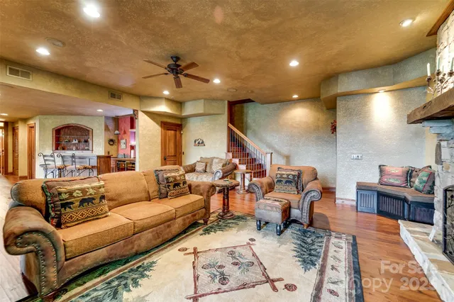 a living room with furniture kitchen view and a chandelier
