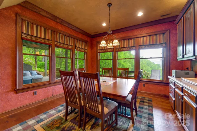 a view of a dining room with furniture large windows and wooden floor