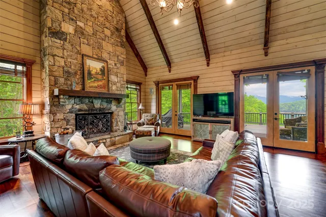 a living room with furniture a fireplace and floor to ceiling windows