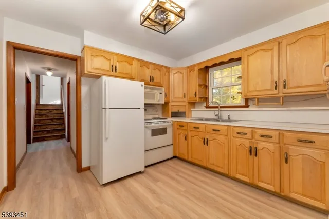a view of a room with wooden floor staircase and a kitchen
