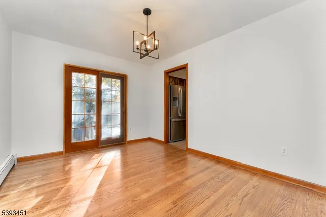 a kitchen with granite countertop wooden floors stainless steel appliances a sink and a window