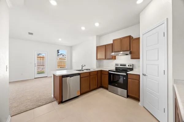 a large kitchen with stainless steel appliances granite countertop a stove and a refrigerator