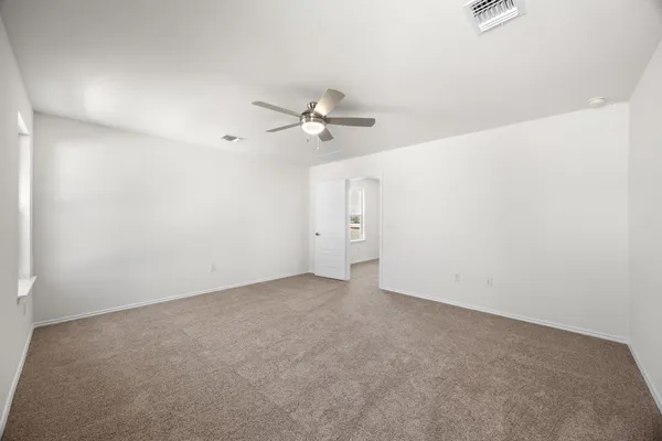 an empty room with a ceiling fan and wooden floor