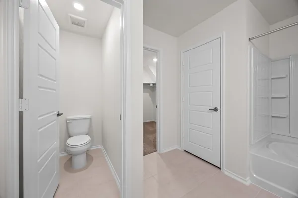 a bathroom with a granite countertop toilet and a bathtub