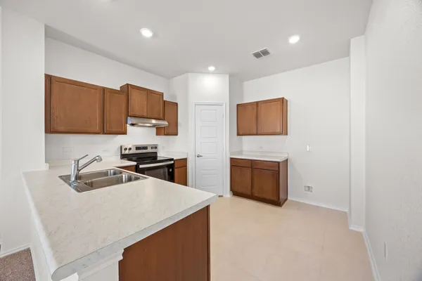 a kitchen with granite countertop a sink stove and refrigerator