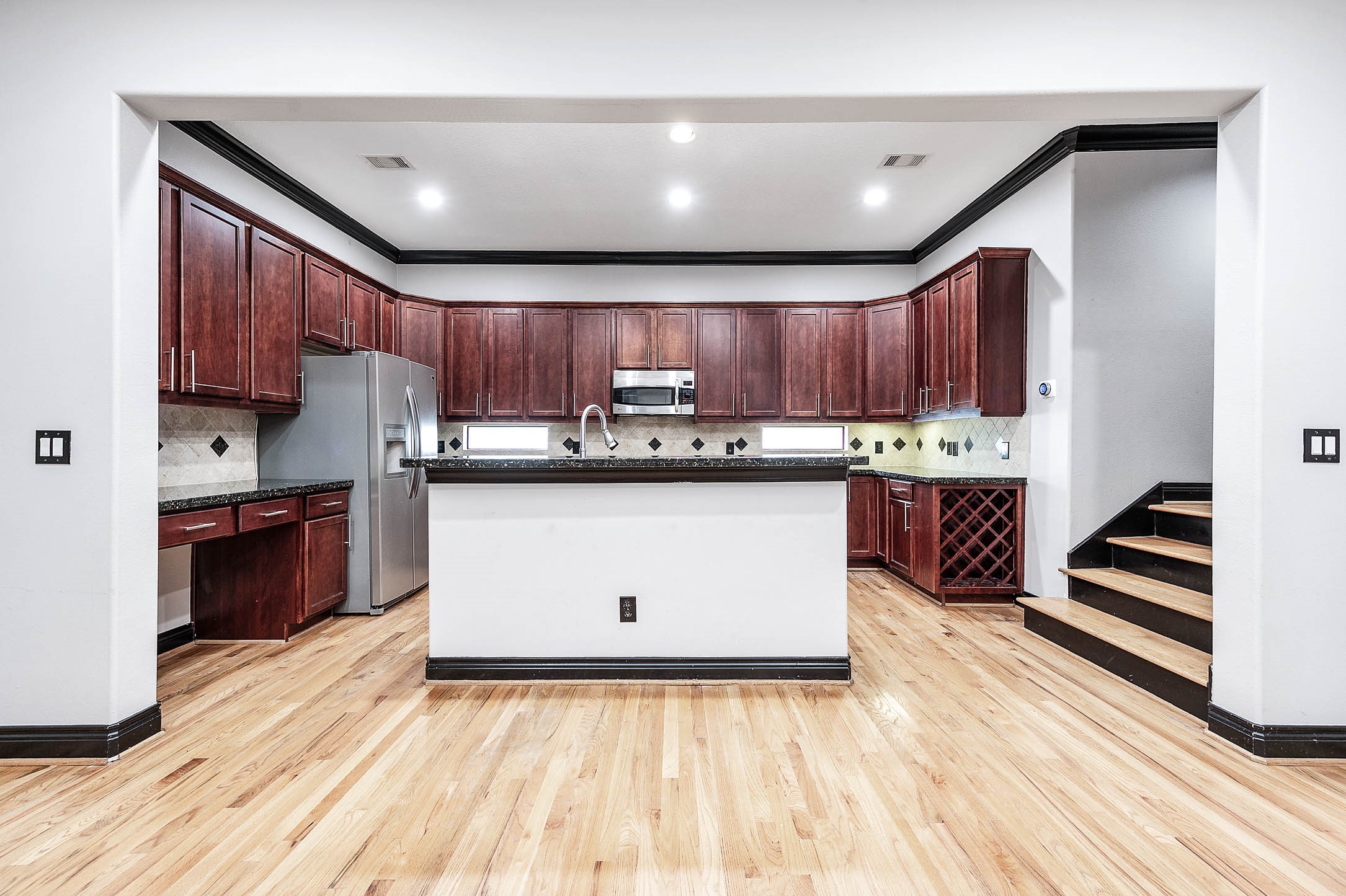 2503 Dallas Street Houston, TX 77003 - Photo 14 of 30 a kitchen with a sink a stove cabinets and wooden floor