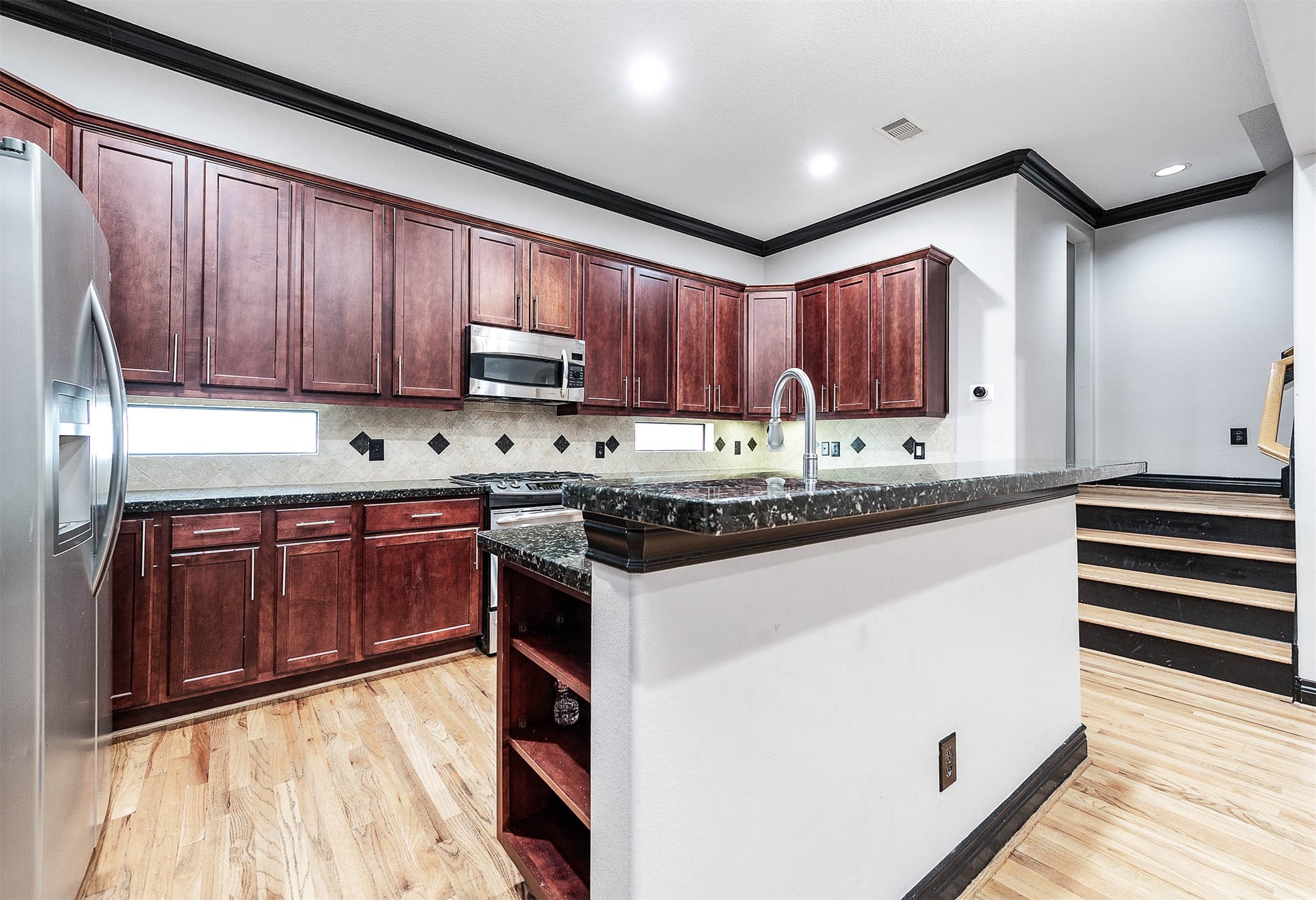 2503 Dallas Street Houston, TX 77003 - Photo 15 of 30 a kitchen with granite countertop wooden cabinets and white appliances