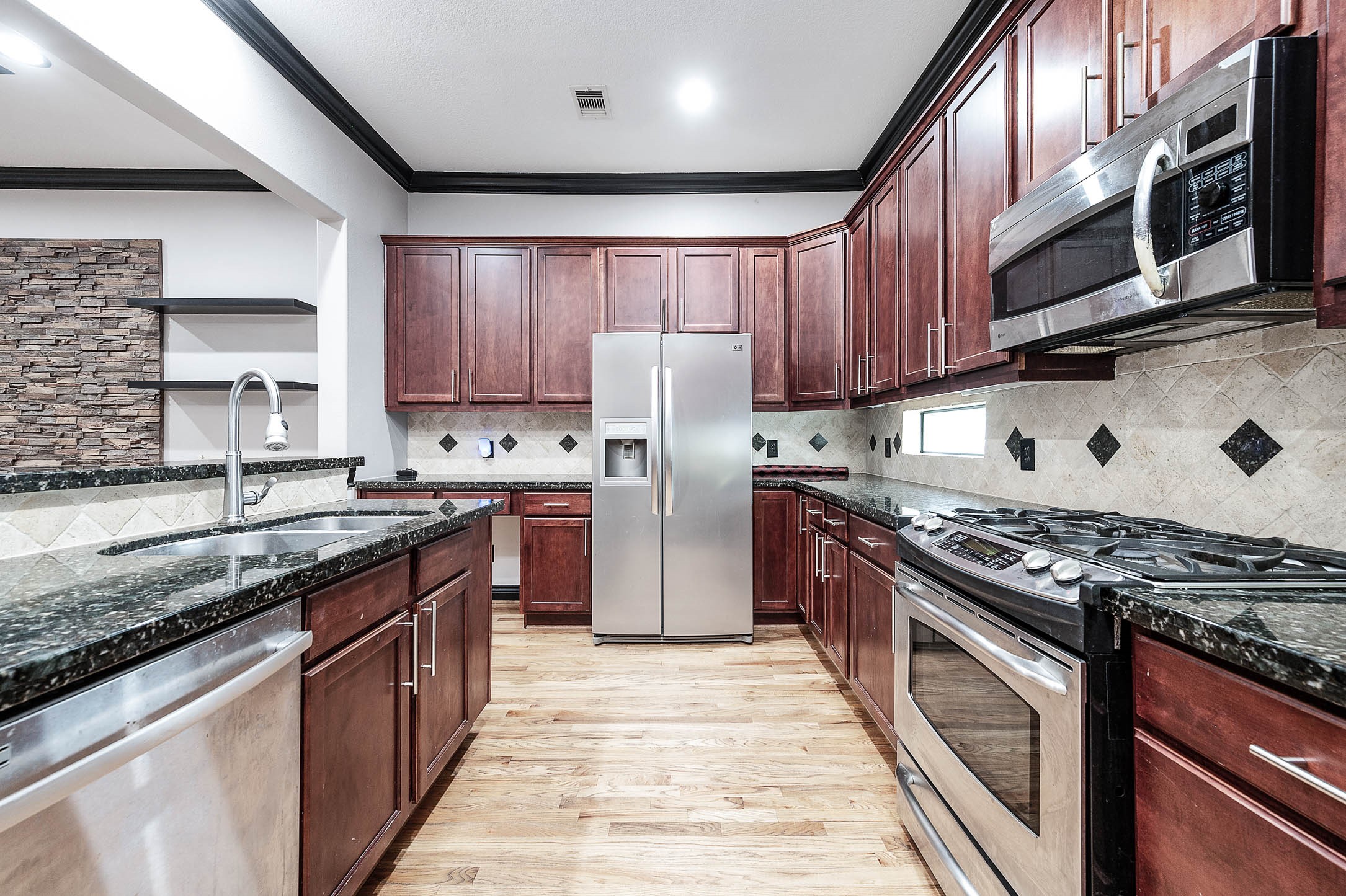 2503 Dallas Street Houston, TX 77003 - Photo 17 of 30 a kitchen with stainless steel appliances granite countertop a stove top oven a sink dishwasher a refrigerator and a cabinets