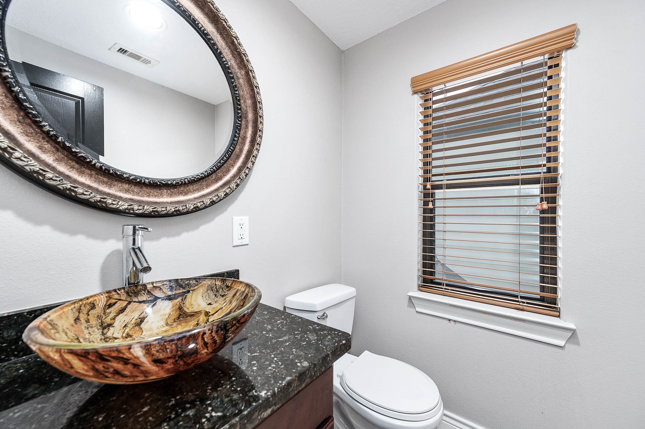 2503 Dallas Street Houston, TX 77003 - Photo 19 of 30 a bathroom with a granite countertop toilet and a mirror