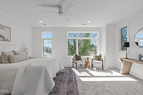 a spacious bedroom with a bed a table and chair