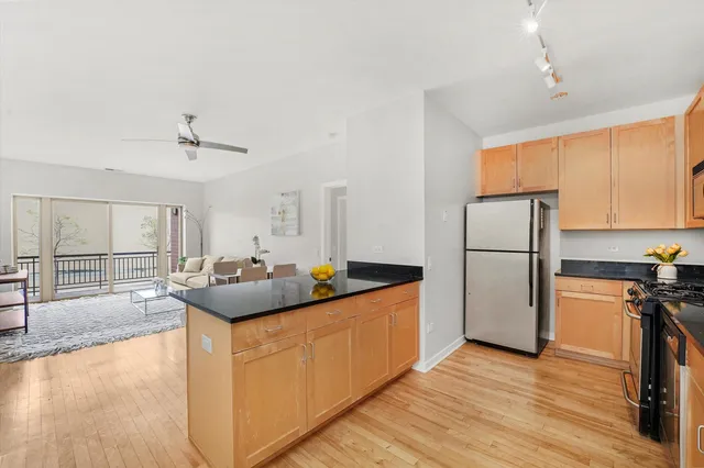 a kitchen with sink a refrigerator and wooden cabinets