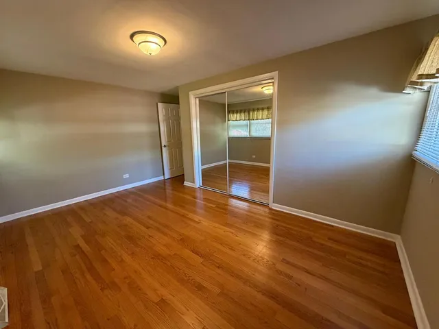 an empty room with wooden floor and closet