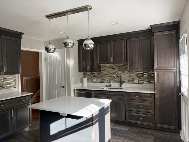 a kitchen with kitchen island stainless steel appliances a sink stove and refrigerator