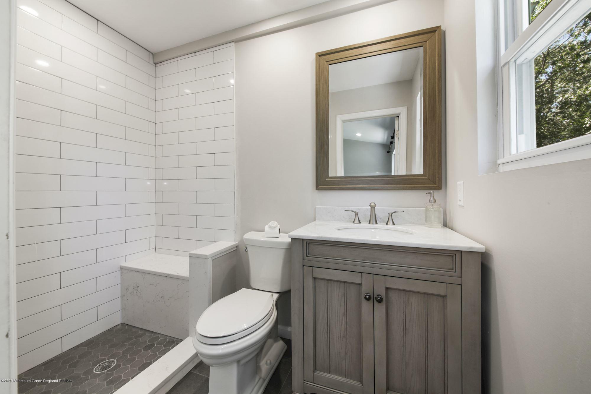 8 Unity Drive Brick, NJ 08723 - Photo 15 of 22 a bathroom with a granite countertop toilet a sink and a mirror