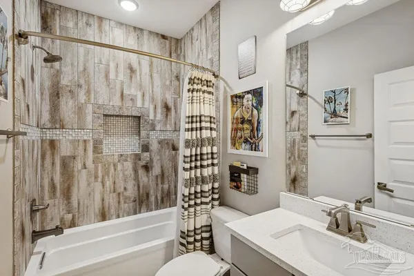 a view of a white house next to a yard with big trees