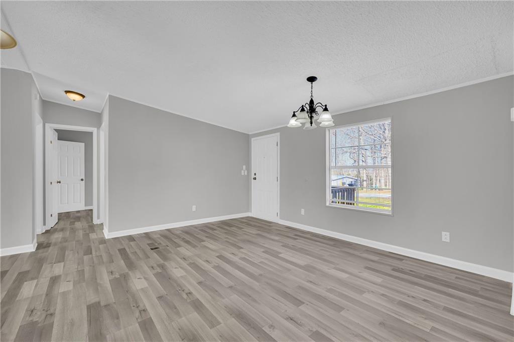 85 Winding Vine Lane Nicholson, GA 30565 - Photo 3 of 40 a view of an empty room with wooden floor and a window