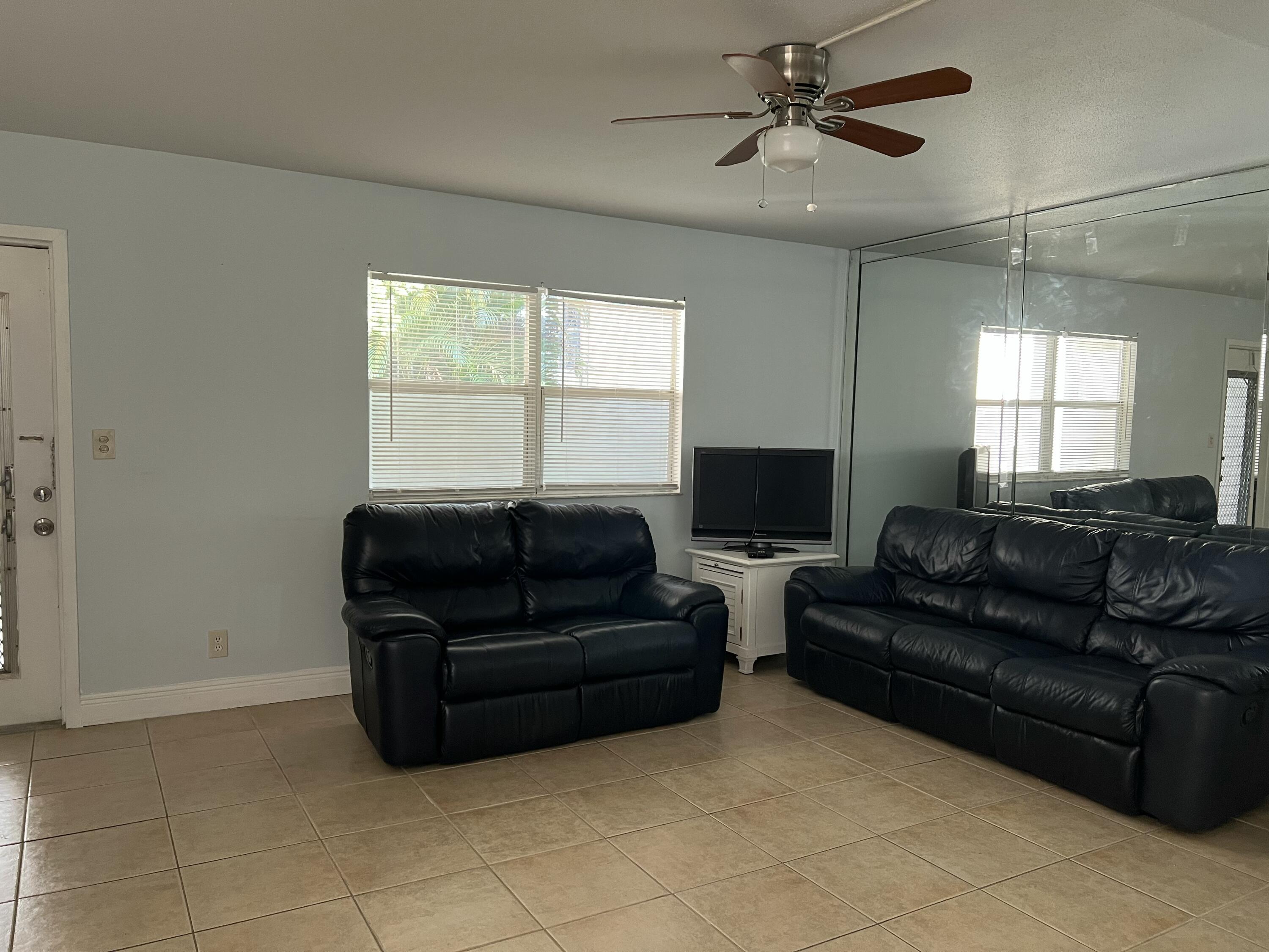 631 Brittany Lane Delray Beach, FL 33446 - Photo 10 of 11 a living room with couches and a flat screen tv