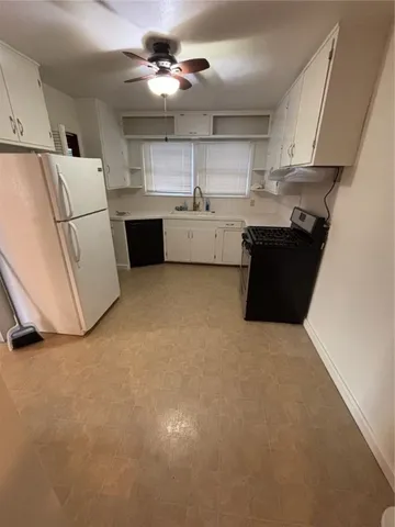 a kitchen with kitchen island white cabinets and refrigerator