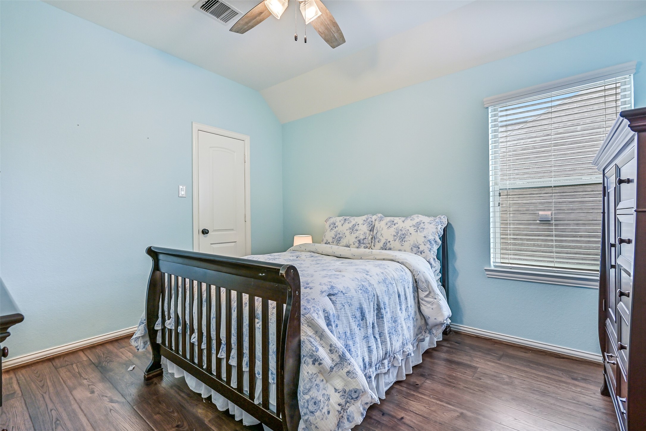 1008 Point Isabel Lane Friendswood, TX 77546 - Photo 39 of 50 A well sized secondary bedroom offers wood look flooring, soft natural light from a side facing window, a lighted ceilng fan, a step in closet, and an appealing color palette, creating a comfortable and versatile space for guests or family.