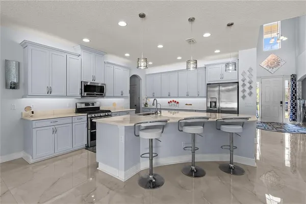 a kitchen with white cabinets stainless steel appliances and kitchen island