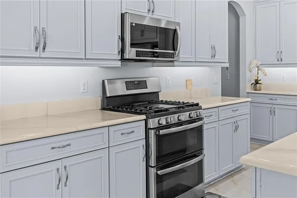 a kitchen with white cabinets and stainless steel appliances