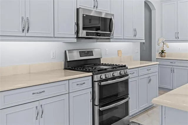 a kitchen with white cabinets and stainless steel appliances