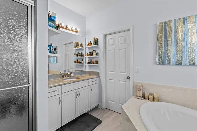 a en suite bathroom with a double vanity sink a mirror and a bathtub