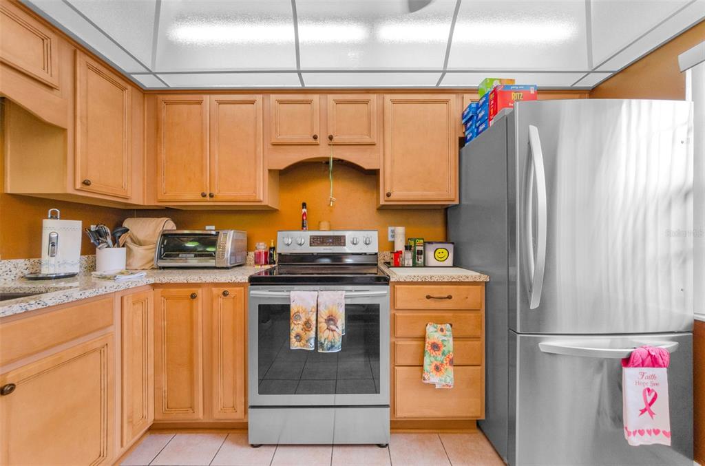 2119 Elm Street, Unit 103 Dunedin, FL 34698 - Photo 20 of 69 a kitchen with stainless steel appliances granite countertop a refrigerator a stove and a sink
