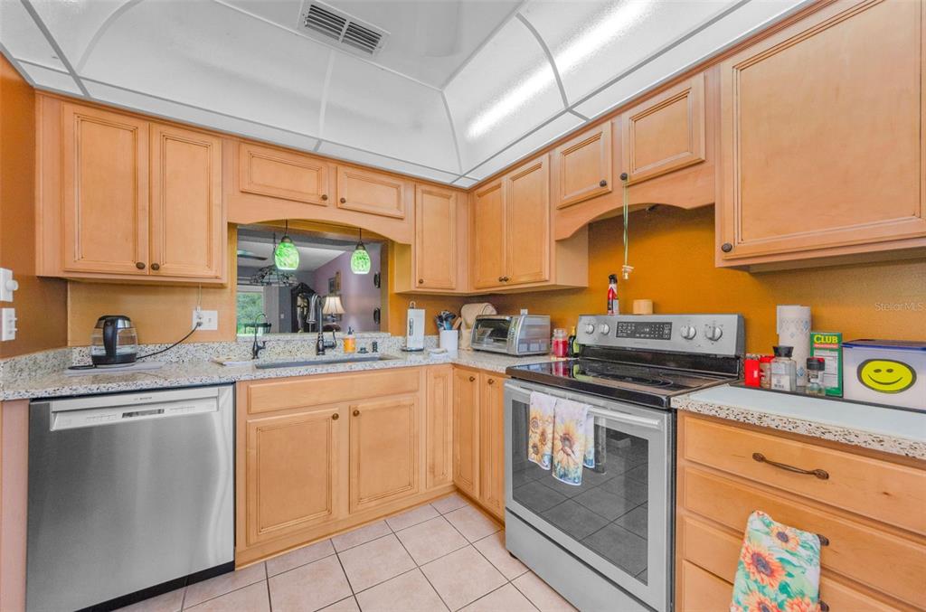 2119 Elm Street, Unit 103 Dunedin, FL 34698 - Photo 21 of 69 a kitchen with stainless steel appliances granite countertop a sink and cabinets
