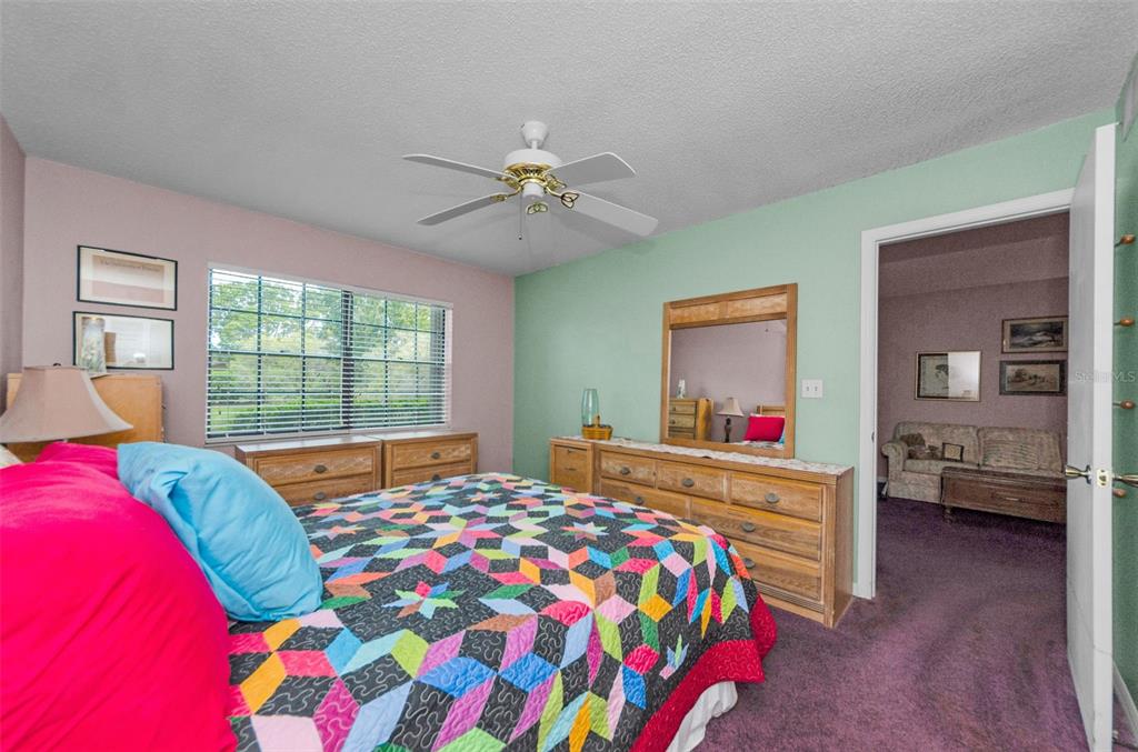2119 Elm Street, Unit 103 Dunedin, FL 34698 - Photo 26 of 69 a bedroom with a bed and a chandelier