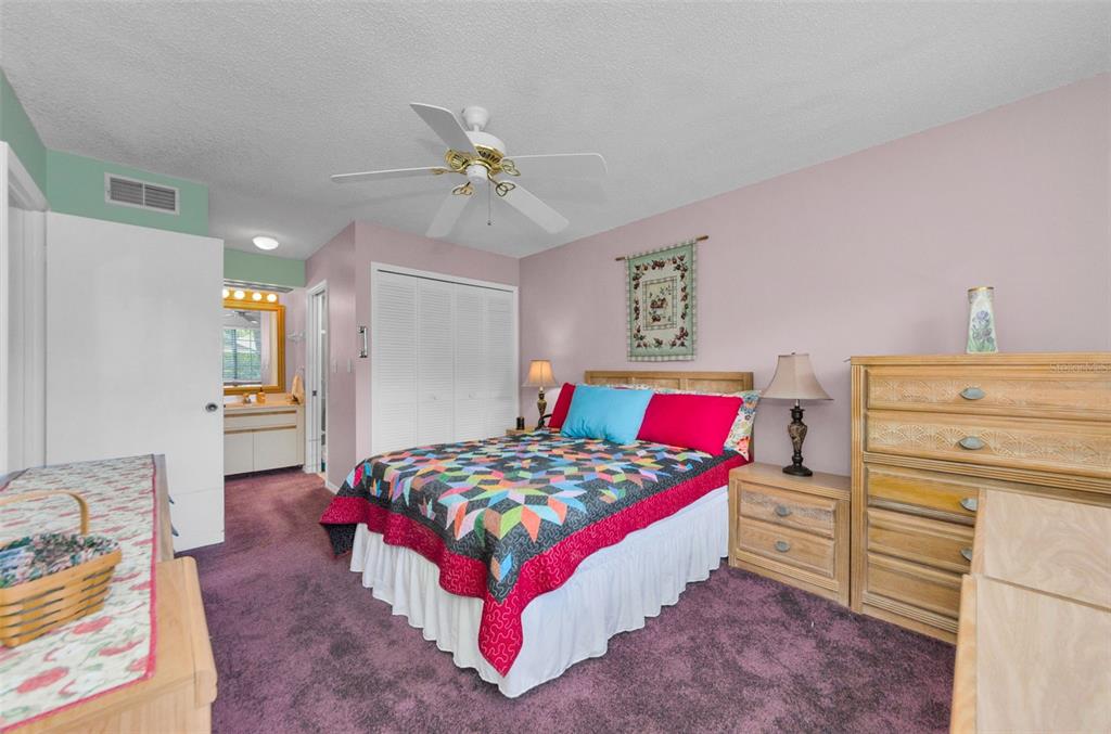 2119 Elm Street, Unit 103 Dunedin, FL 34698 - Photo 27 of 69 a bedroom with a bed and a chandelier