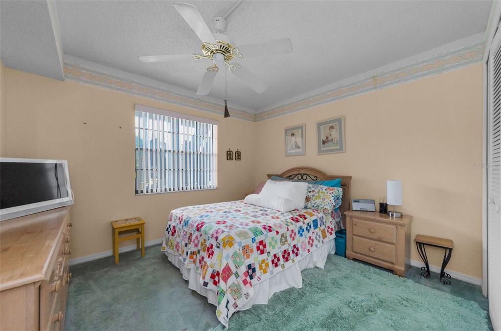 2119 Elm Street, Unit 103 Dunedin, FL 34698 - Photo 30 of 69 a bedroom with a bed and a tv on the dresser