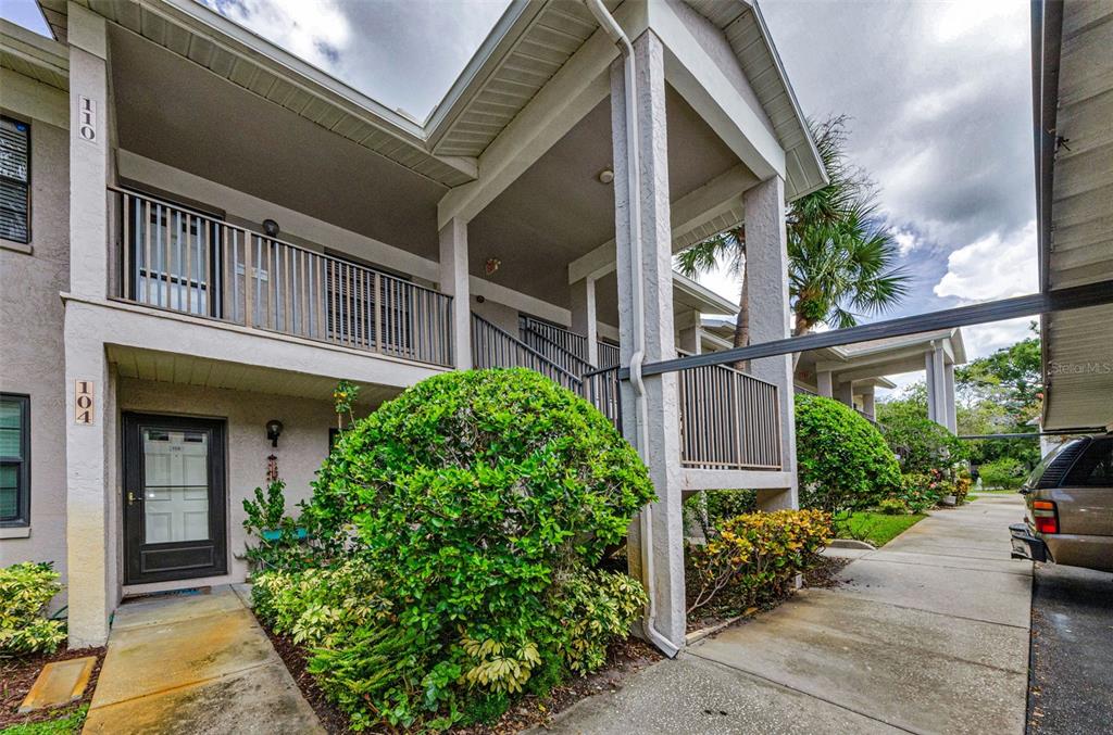 2119 Elm Street, Unit 103 Dunedin, FL 34698 - Photo 4 of 69 a view of a brick house with a large windows and flower plants