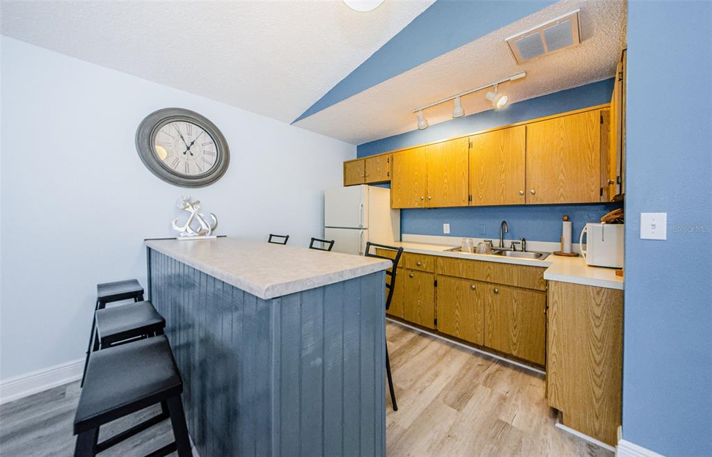 2119 Elm Street, Unit 103 Dunedin, FL 34698 - Photo 45 of 69 a kitchen with a sink cabinets and a refrigerator