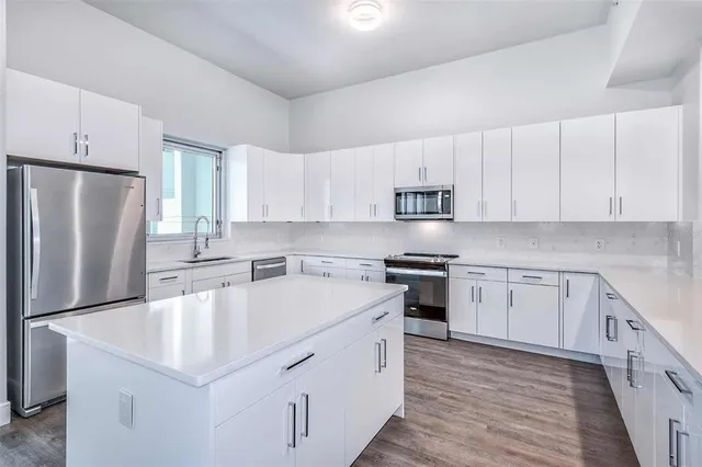 a kitchen with stainless steel appliances cabinets a sink and a center island
